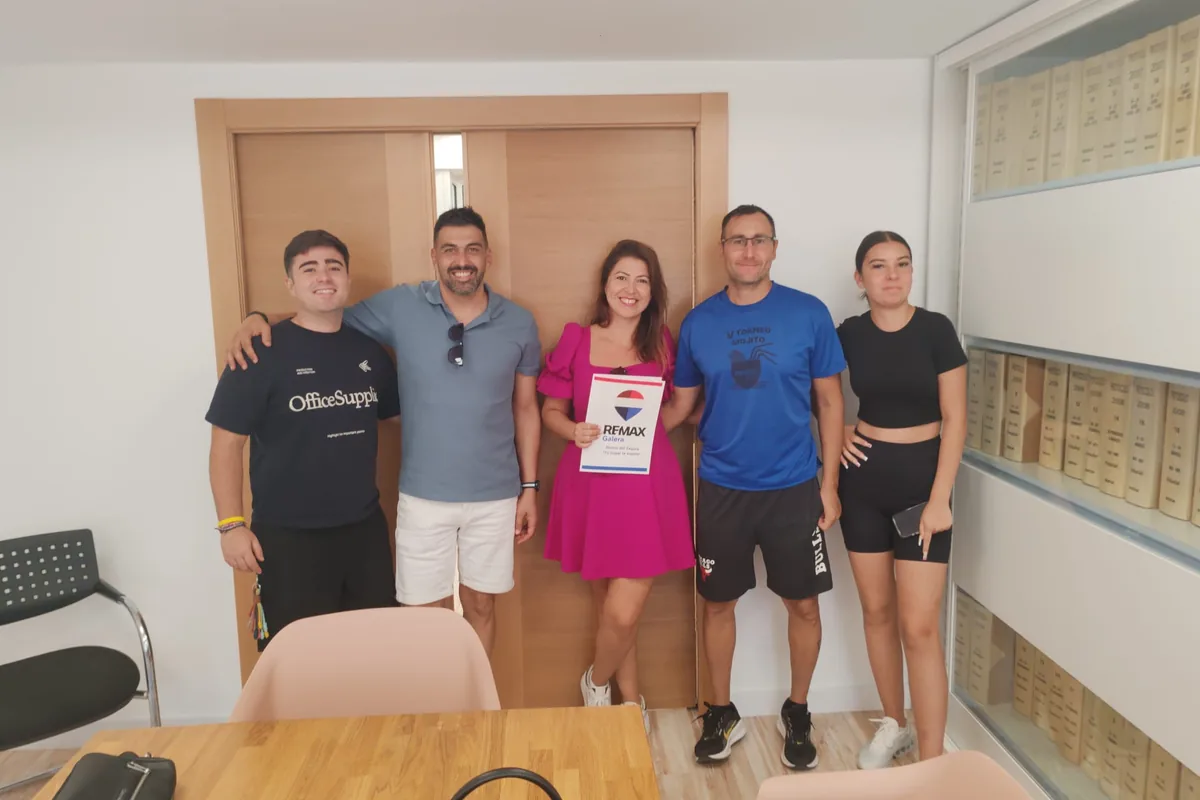 Familia joven tras la firma con su asesora de REMAX Galera
